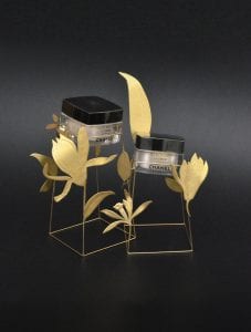 Thekendisplays im Pflegebereich können so aussergewöhnlich sein wie diese in Chanel Cremes die in goldenen Blumen zu schweben scheinen.